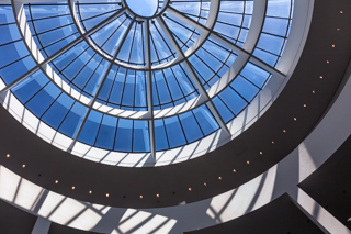 Ein großes rundes Dachfenster in der Pinakothek der Moderne von unten fotografiert