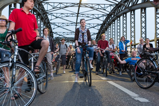 Fahrradfahrer auf einer Brücke von unten fotografiert