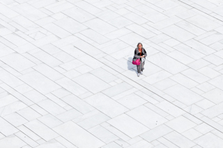 Eine Frau läuft über einen Platz vor der Oper in Oslo, der Platz ist weiss und sie hat bunte Kleidung an. Ein schöner Farbkontrast